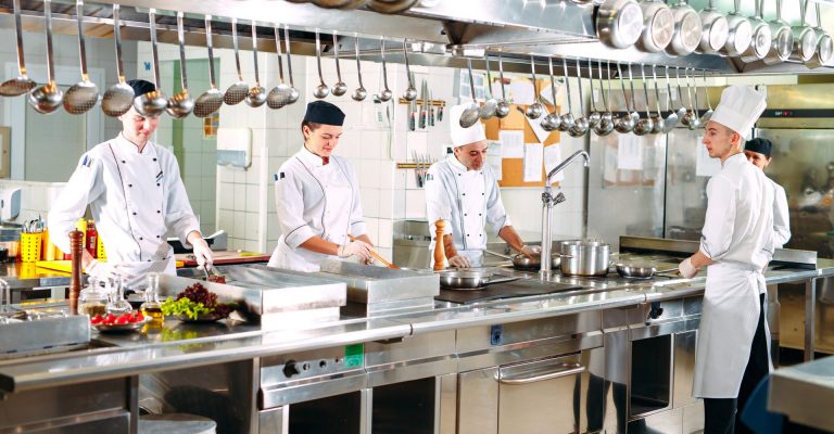 Ausbilder kocht mit seinen Azubis in der Küche